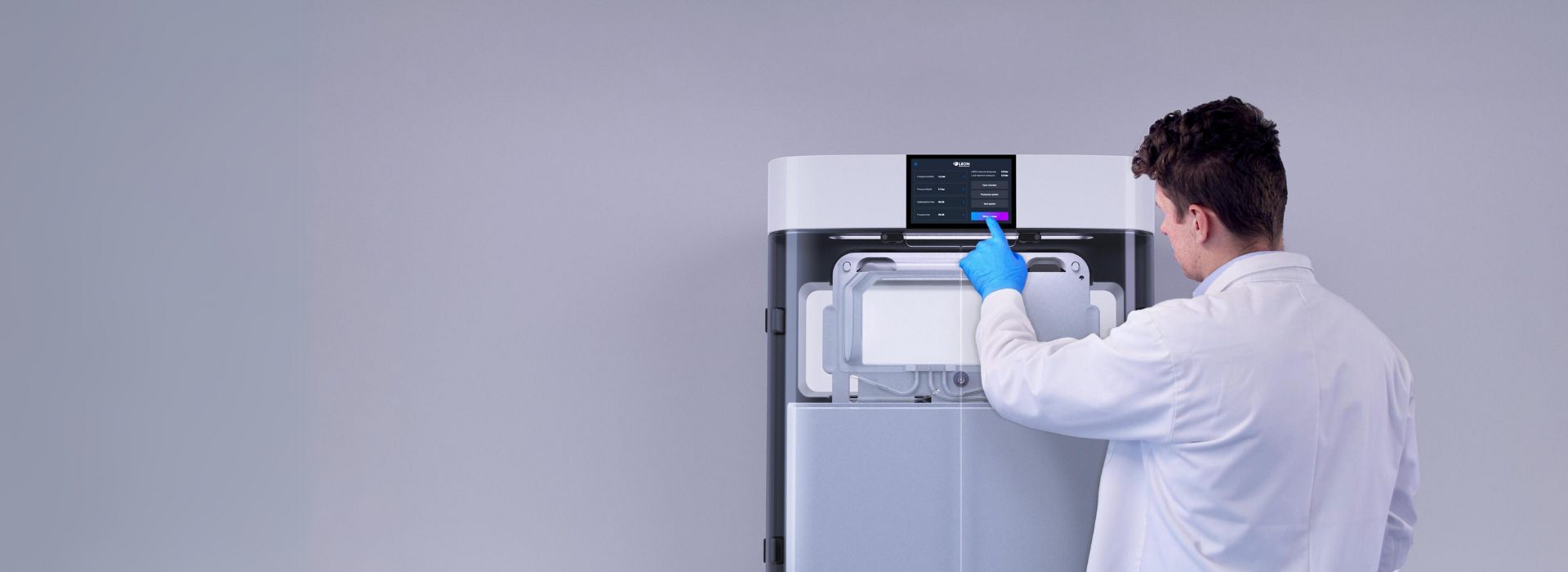 lab technician standing in front of a benchtop system interacting with screen (2)